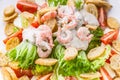 Close-up salad with shrimp, lettuce, cheese, avocado and crackers on a white plate. Delicious and healthy seafood recipes Royalty Free Stock Photo