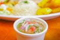 Close up of sald inside of a white bowl and a blurred fried fish served in a white plate over a wooden table Royalty Free Stock Photo