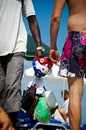 Close up of salesman on the beach selling earphones and purses