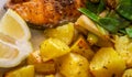 Close-up of salmon cutlet with potatoes on spring onions and sugar snap peas Royalty Free Stock Photo