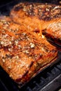 Close up of Salmon with garlic and clove rub on cedar planks cooking on BBQ grill