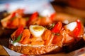 Close up of salmon toast starter or appetizer with egg and tomato on sun light. Bread slice with salted smoked salmon