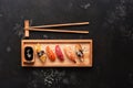 Close up of sashimi sushi set with chopsticks and soy sauce, dark stone background. Top view, copy space Royalty Free Stock Photo