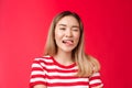 Close-up sassy carefree outgoing urban asian female student enjoy summer vacation wear striped t-shirt, show tongue