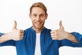 Close up of satisfied happy guy shows thumbs up and smiles, praise something good, excellent job, compliment your effort