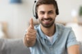 Close up satisfied man in headset showing thumbs up, approval