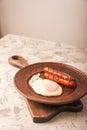 Close-up of sausages and fried eggs. Sausages on a plate and place for text. Breakfast fried eggs and bavarian sausages on a clay