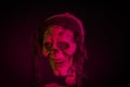 Close up of scary view of skeleton head with red backlight on black background. Halloween concept.
