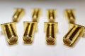 Close-up of scattered gold plated SMA male connectors electronics components in partial focus on white background