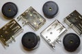 Close-up of scattered USB socket and buzzer electronics components on white background in partial focus and random pattern