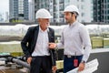 Close up scene with two engineers or technicians talk together and stay on rooftop of construction site Royalty Free Stock Photo