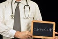 Check-up writing on a school slate held by a doctor Royalty Free Stock Photo