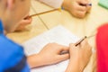 Close up of schoolboy writing test at school