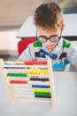 Close-up of schoolkid counting abacus in classroom