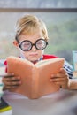 Close-up of schoolkid reading book in classroom