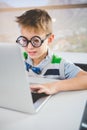 Close-up of schoolkid using laptop in classroom