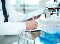 science lab technician with a digital tablet making notes on the clipboard. Royalty Free Stock Photo