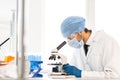 Close up. scientist looking into the eyepiece of a microscope.