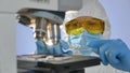 Close-up shot of a scientist looking at a glass slide with bacteria preparing for examining under microscope Royalty Free Stock Photo