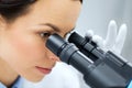 Close up of scientist looking to microscope in lab Royalty Free Stock Photo