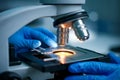 Close-up of a scientist using a microscope in a lab.