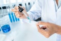 Close up of scientist woman holding dropper to dropping solution sample on the glass plate for microscope Royalty Free Stock Photo