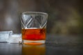 Close up of Scotch whiskey or Grain scotch in a transparent glass with ice cubes on black colored wooden surface. Royalty Free Stock Photo