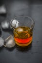 Close up of Scotch whiskey or Grain scotch in a transparent glass with ice cubes on black colored wooden surface. Royalty Free Stock Photo
