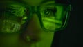 Close Up Of Screen Reflected In Glasses Of Female Computer Hacker Writing Code 