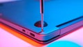 Close-up of screwing bolt into laptop cover in red blue light Royalty Free Stock Photo