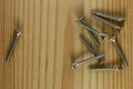 Close-up on screws, metal screws, iron screws, wood screws on wooden board Royalty Free Stock Photo