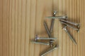 Close-up on screws, metal screws, iron screws, wood screws on wooden board Royalty Free Stock Photo