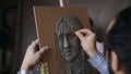 Close-up of Sculptor creating sculpture of human`s face on canvas in art studio Royalty Free Stock Photo