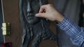 Close-up of Sculptor creating sculpture of woman`s face on canvas in art studio