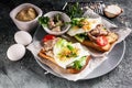 Close-up sea food sandwich. Cod liver, fresh lettuce, pea sprouts, tomatoes and fried eggs. Healty and tasty breakfast on a