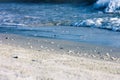 Close up sea water waves with bubbles on sand beach, background Royalty Free Stock Photo
