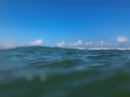 Close up of sea wave. Front view on beautiful sea wave on sandy beach. Summer sunny day, blue sky, water background. Blur effect Royalty Free Stock Photo