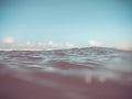 Close up of sea wave. Front view on beautiful sea wave on sandy beach. Summer sunny day, blue sky, water background.Blur effect Royalty Free Stock Photo