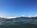 Close up of sea wave. Front view on beautiful sea wave on sandy beach. Summer sunny day, blue sky, water background Royalty Free Stock Photo