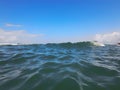 Close up of sea wave. Front view on beautiful sea wave on sandy beach. Summer sunny day, blue sky, water background Royalty Free Stock Photo