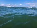 Close up of sea wave. Front view on beautiful sea wave on sandy beach. Summer sunny day, blue sky, water background Royalty Free Stock Photo