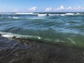 Close up of sea wave with splashes. Front view on beautiful sea wave on sandy beach. Summer sunny day, water background Royalty Free Stock Photo