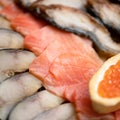 Close-up of Seafood plate. Slices of red salmon fish, pieces of mackerel and sandwich with red caviar in foreground Royalty Free Stock Photo