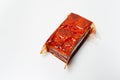 Close-up of sealed smoked tofu isolated on white background.