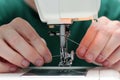 Close-up seamstress hands working on sewing machine at home. Sewing process. woman hands behind sewing close-up. The process of