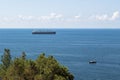 Close-up of the seascape. Blue sea, clouds over the horizon and cargo ships