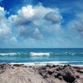 Close up seascape with sandy beach and waves on sea over cloudy