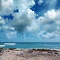 Close up seascape with sandy beach and waves on sea over cloudy