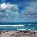 Close up seascape with sandy beach and waves on sea over cloudy