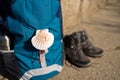 Close up of a seashell symbol of Camino de Santiago on backpack and trekking boots